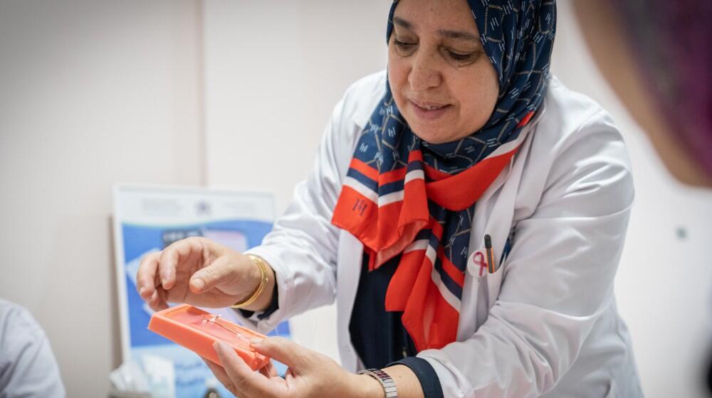 Une professionnelle de santé montre un DIU à une femme